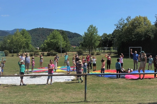 Eine Gruppe spielender Kinder auf einer Gr&uuml;nfl&auml;che