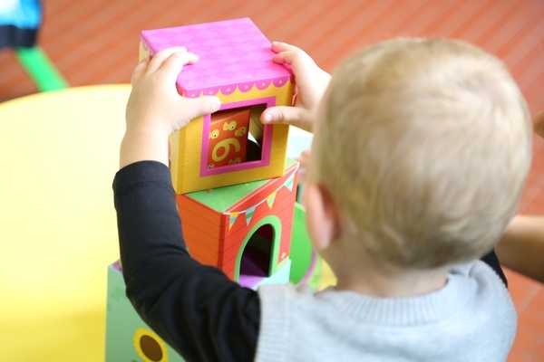 Ein Kind baut mit farbigen Elementen einen Turm