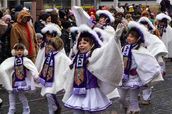 Fastnachtsumzug mit Kindern in wei&szlig;/lilanem Garde-Kost&uuml;m