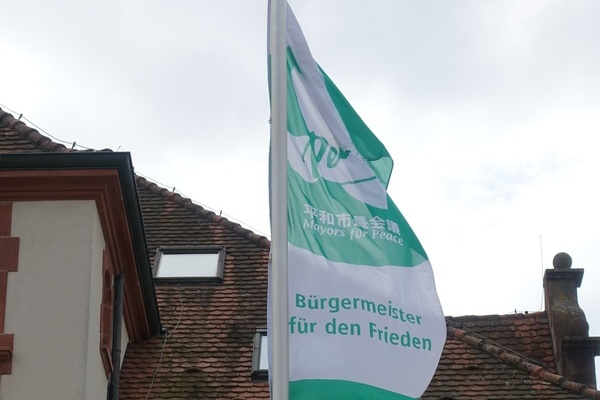 Die Flagge der Mayors for Peace (Bürgermeisterinnen und Bürgermeister für den Frieden) weht ab dem 8. Juli am Denzlinger Rathausplatz