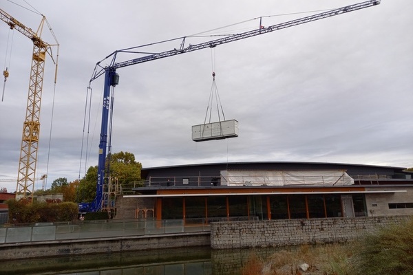 Per Kran wird die rund drei Tonnen wiegende Be- und Entlüftungsanlage auf das Dach des Kultur & Bürgerhauses gehoben. Foto: Gemeinde Denzlingen