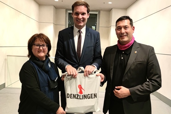 Sibylle Pfister (links), Leiterin der Stabsstelle Steuerung, Koordination & Klimaschutz im Denzlinger Rathaus, und B&uuml;rgermeister Markus Hollemann (rechts) &uuml;berreichen Yannik Bury MdB Leckereien aus Denzlingen. Foto: Gemeinde Denzlingen
