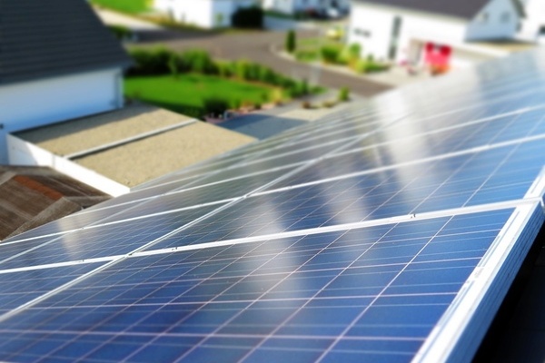 Blick vom Dach eines Wohngeb&auml;udes hinunter und &uuml;ber ein schwarzes PV-Modul