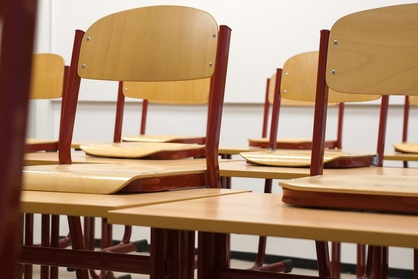 Holzstühle auf Schultischen in einem Klassenzimmer