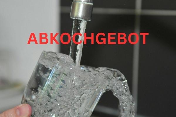 Aus Wasserhahn fliet Wasser in ein Trinkglas