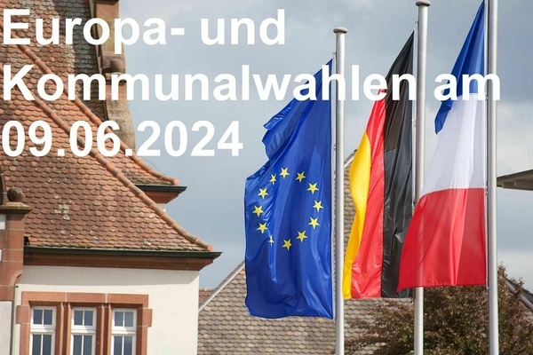 Europäische, deutsche und französische Flagge neben dem Denzlinger Alten Rathaus, weiße Schrift