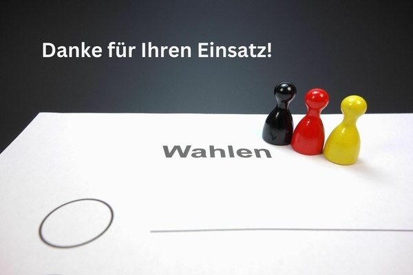 Danke f&uuml;r Ihren Einsatz. Wei&szlig;e Schrift auf dunklem Grund. Drei Spielfiguren in den Farben der deutschen Flagge.