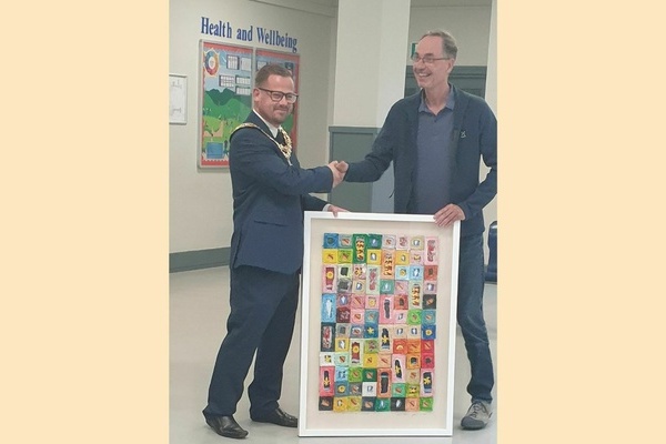 Bild: Andreas Berger (rechts), Mitglied des Partnerschaftskomitees, übergibt die Collage des Denzlinger Künstlers Joachim Walz an den Bürgermeister von North Hykeham, Matt Lofts.Foto: Partnerschaftskomitee der Gemeinde Denzlingen.