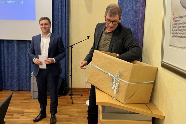 Lars Br&uuml;gner (rechts) begutachtet sein Abschiedsgeschenk des Gemeindeverwaltungsverbandes Denzlingen, V&ouml;rstetten, Reute, &uuml;berreicht vom Verbandsvorsitzenden Fabian Nitz. Foto: Gemeinde Denzlingen