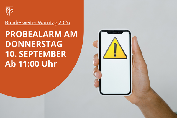 Ein Handy zeigt ein gelbes Warndreieck. Links der Hinweis: Bundesweiter Warntag 2026; Probealarm am Donnerstag, 10. September ab 11 Uhr. Bild erstellt mit Canva und KI.