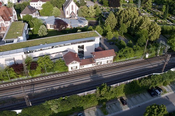 Luftbild mit begrüntem Dach neues Rathaus sowie Bahnschienen DB